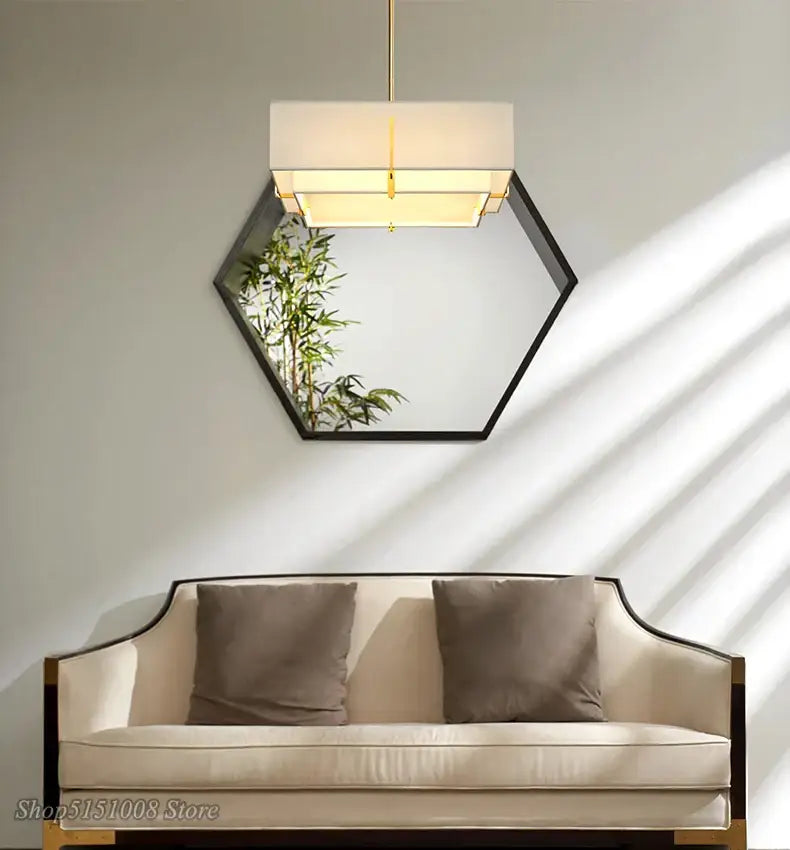 Hexagonal mirror with black frame and white DecorBites pendant lamp above for modern minimalist living room decor
