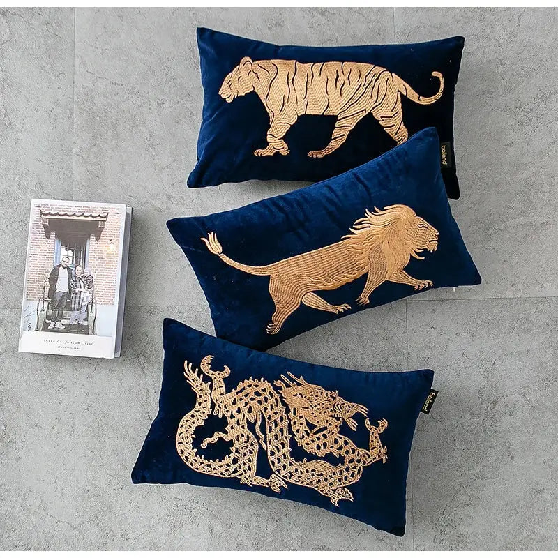 Set of three navy blue velvet pillow covers with gold tiger, lion, and dragon embroidery lumbar designs by DecorBites