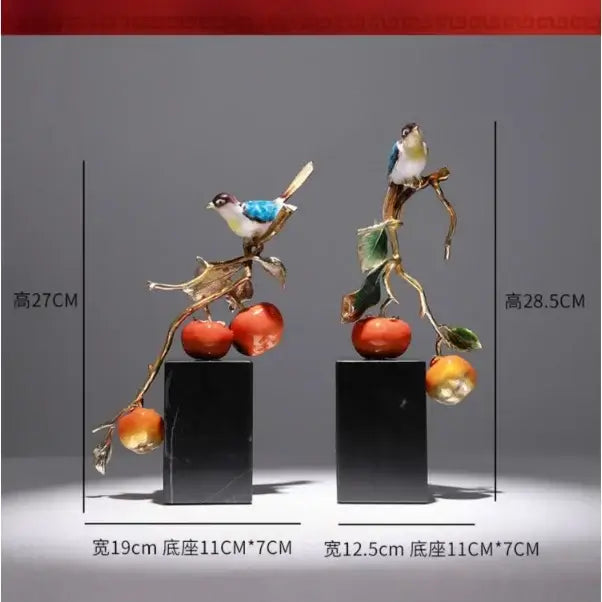 Two enamel persimmon ruyi bird sculptures with blue and white birds and red fruit on black marble bases for décor