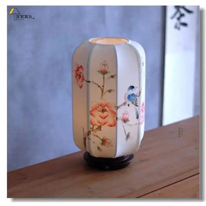 A softly glowing white ceramic desk lamp with delicate hand-painted floral and bird motifs from decorbites chinese fabric desk collection