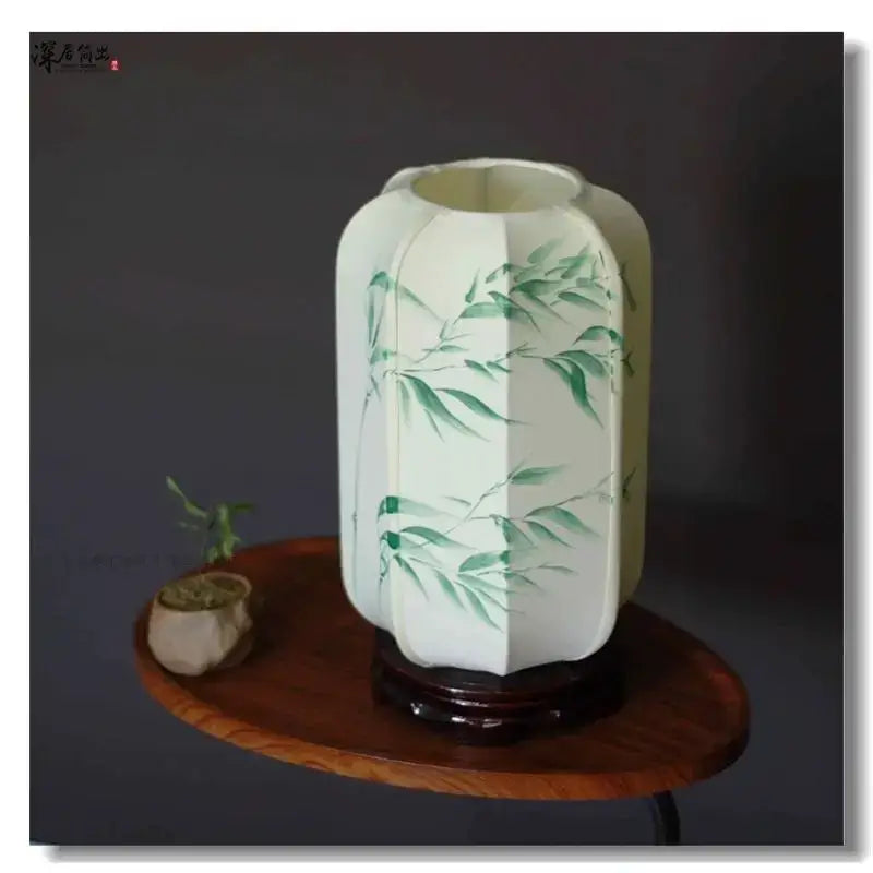 Decorbites chinese fabric desk lamp featuring a white hexagonal paper lantern with green bamboo leaf designs