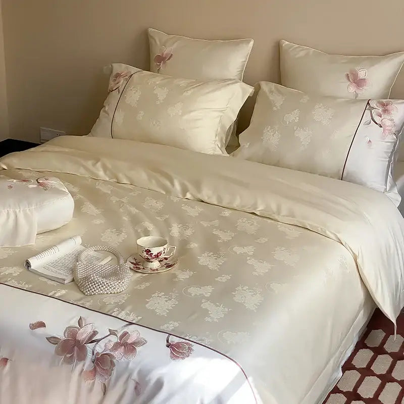 Cream-colored satin bedding set with pink floral embroidery and white accents made from lyocell cotton by DecorBites Chinese Floral