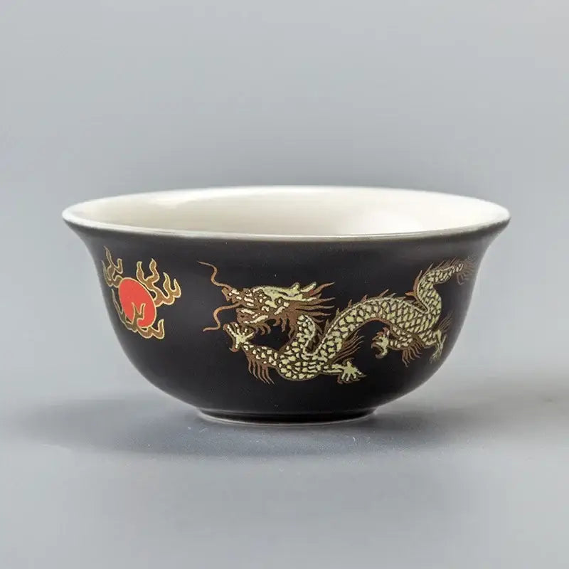 Black ceramic DecorBites™ tea cup with golden dragon and red sun motifs and white interior porcelain vintage mug