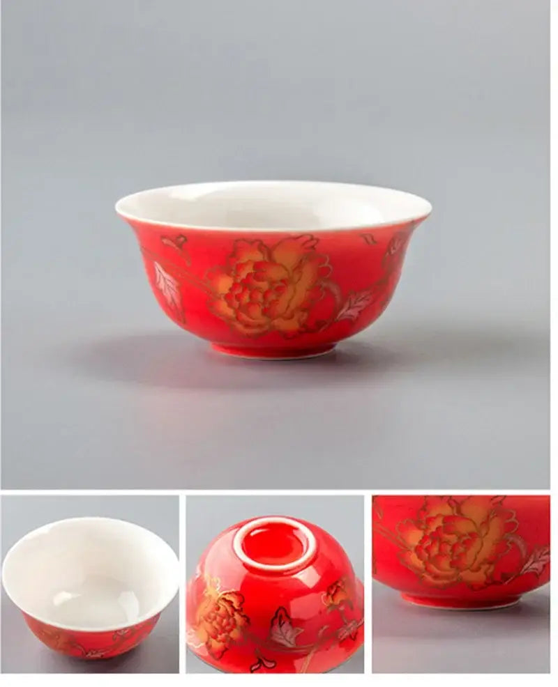 A glossy red ceramic dragon tea cup with intricate golden peony patterns and white interior from decorbites