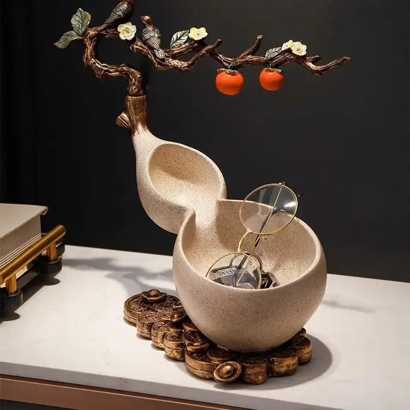 Beige ceramic gourd-shaped desktop storage decoration with bronze branch, white flowers, green leaves, and orange persimmons