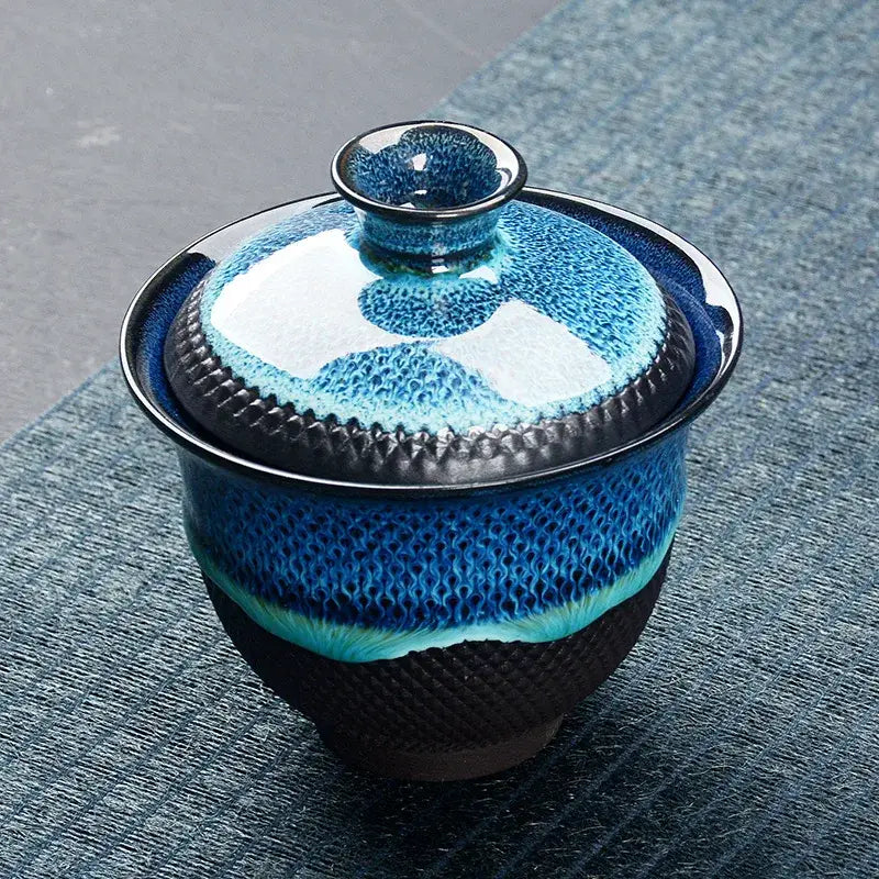 A ceramic teacup with lid featuring textured blue and black glaze in the DecorBites Chinese kung fu tea set