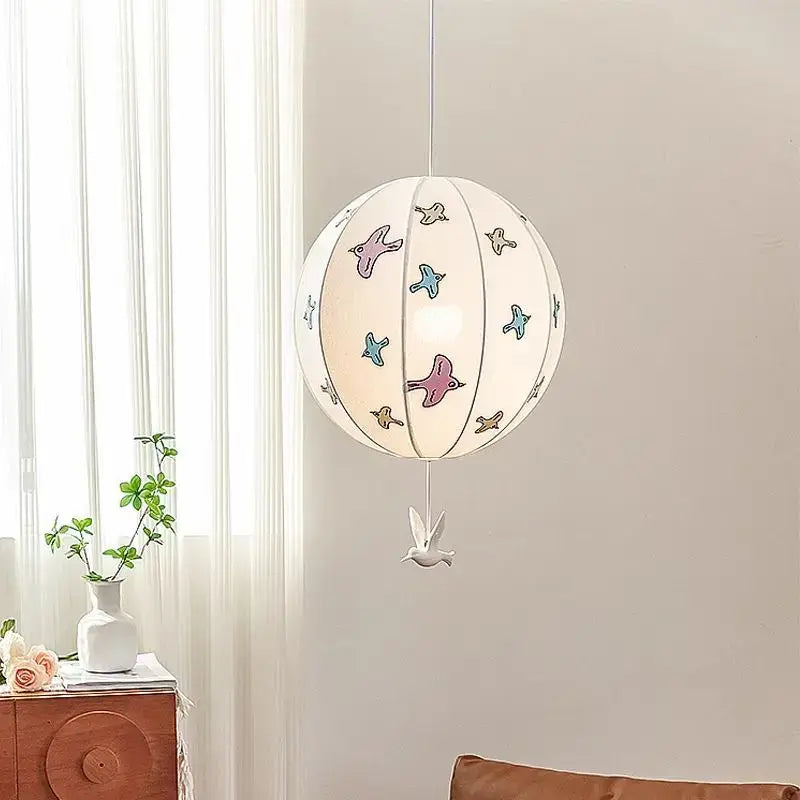 Decorbites chinese medieval pendant light featuring a white paper lantern with colorful birds and a ceramic dove charm