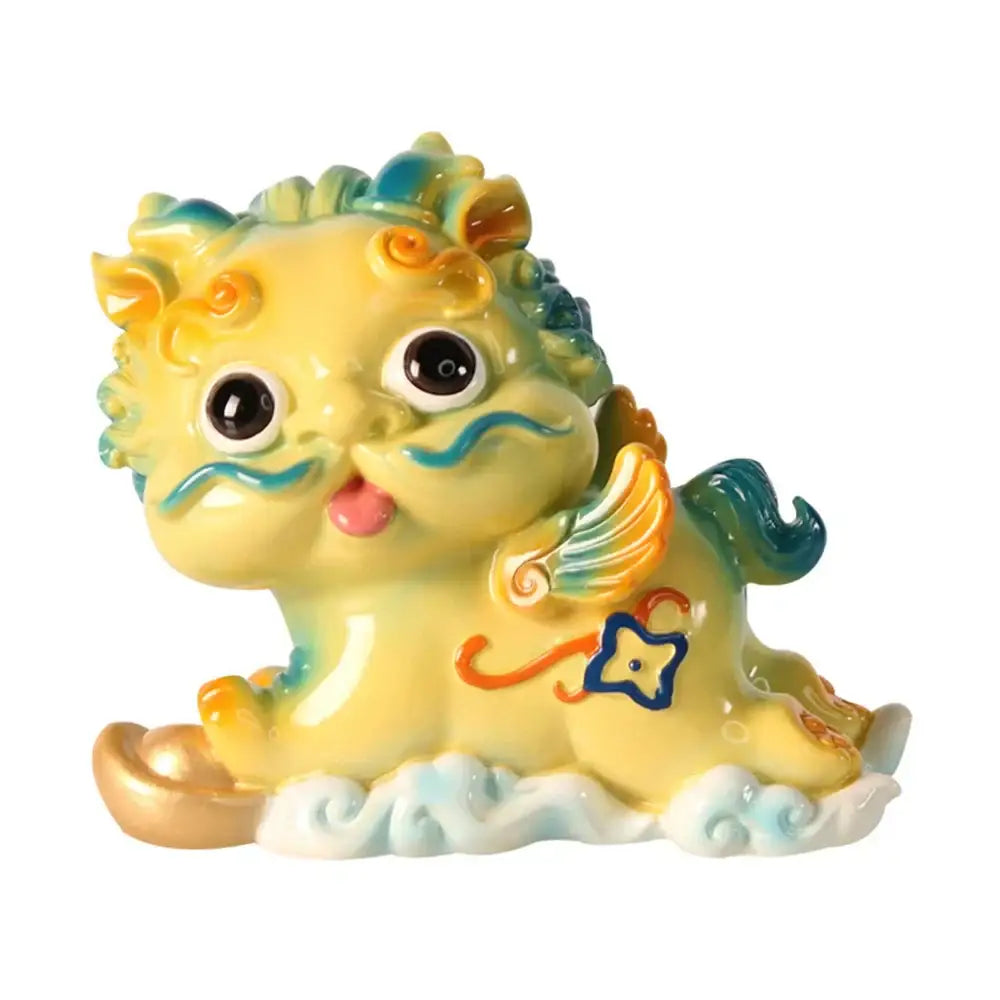 A charming yellow ceramic mythology lion figurine with turquoise and orange accents and decorative wings for luck