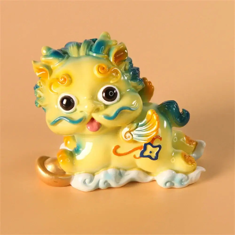 A charming yellow ceramic mythology lion figurine with blue and green accents holding a golden coin for luck and wealth