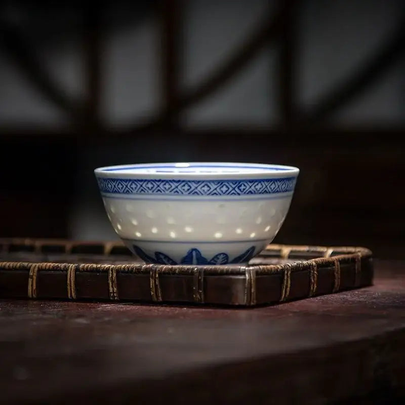 A delicate white porcelain decorbites chinese orchid dragon bowl with blue geometric patterns and a perforated interior