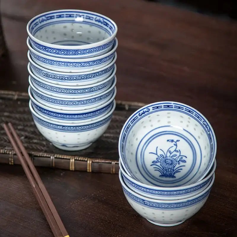 Stack of white ceramic decorbites chinese orchid dragon dessert rice bowls with blue floral and geometric patterns