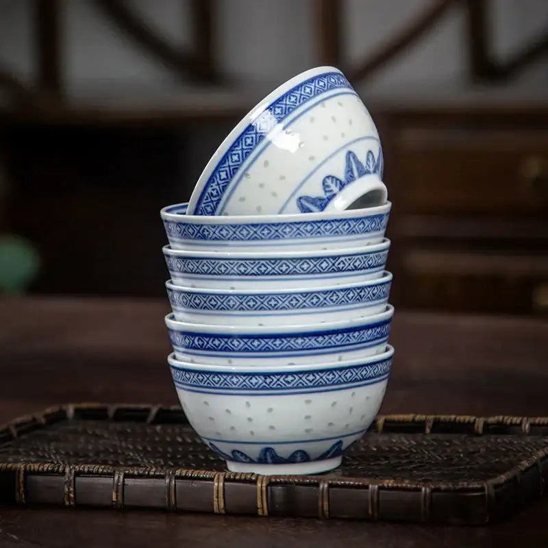 A stack of decorbites chinese orchid dragon white porcelain dessert bowls with intricate blue geometric floral patterns