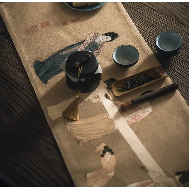 Beige linen table runner featuring embroidered chinese painting women in soft blues and browns with traditional chic decor