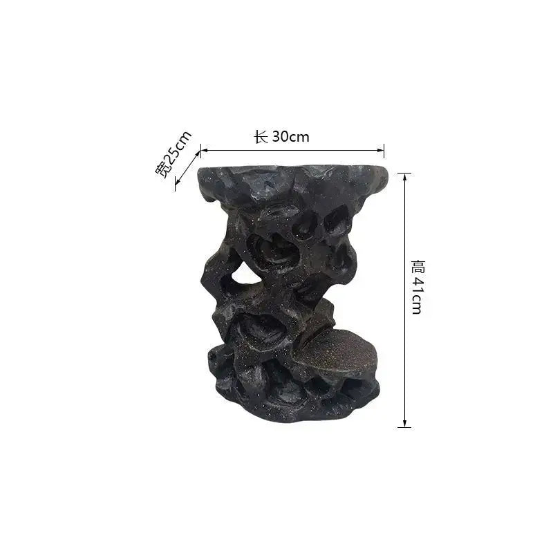 Black intricately carved resin garden stool with rugged design for modern minimalist living room decor by DecorBites