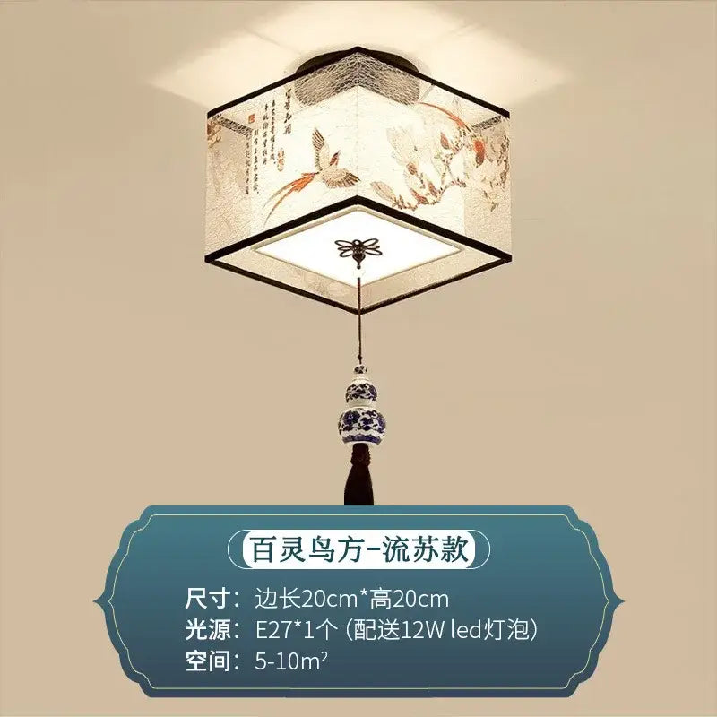 A hexagonal decorbites chinese style ceiling lamp with white fabric shade embroidered with birds and flowers hanging from blue porcelain