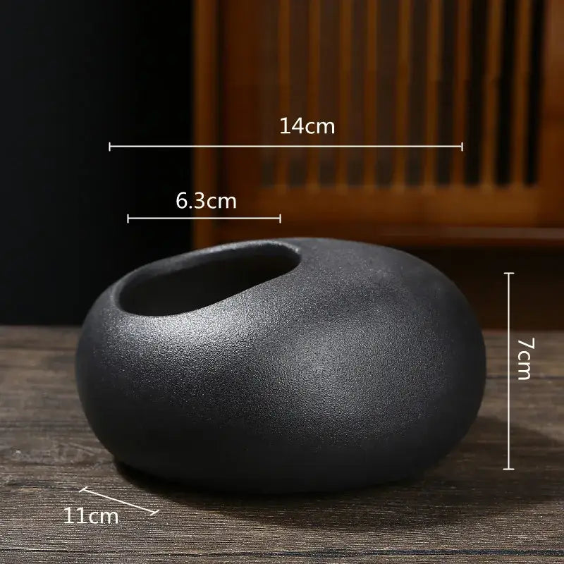 A matte black ceramic flowerpot vase tea scoop with a smooth rounded oval shape for home arrangement