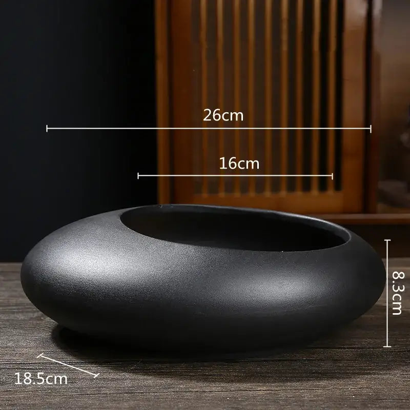 A sleek matte black ceramic flowerpot vase with smooth rounded contours and a shallow wide opening for bonsai decor