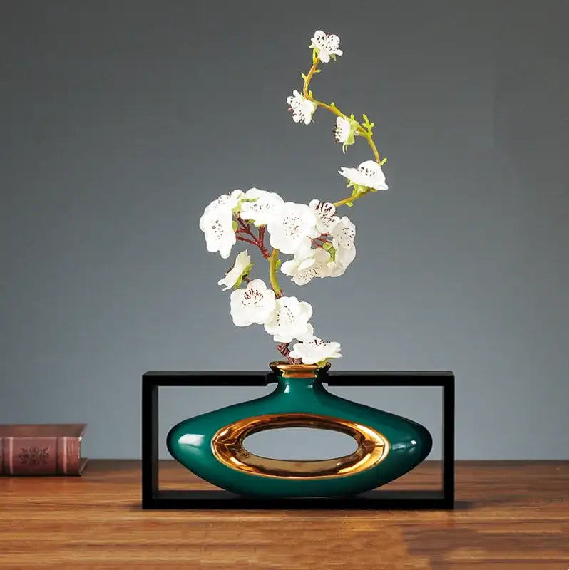 Teal ceramic vase with gold oval accent holding white blossoms in decorbites chinese style ceramic vase wooden frame