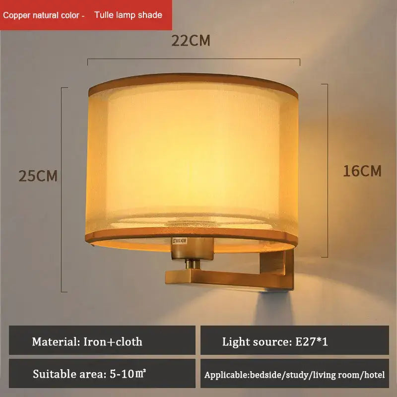DecorBites™ copper-finished cloth covered wall lamp with cylindrical tulle shade emitting warm light for bedroom use