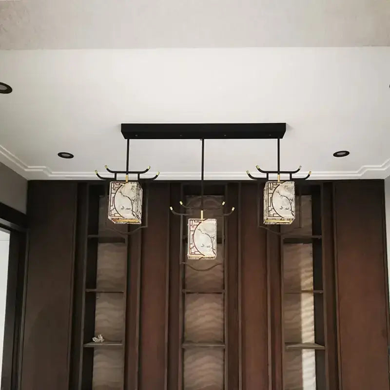 Three copper decorative hall pendant lights with black metal frames and white floral panels for bedroom bedside use