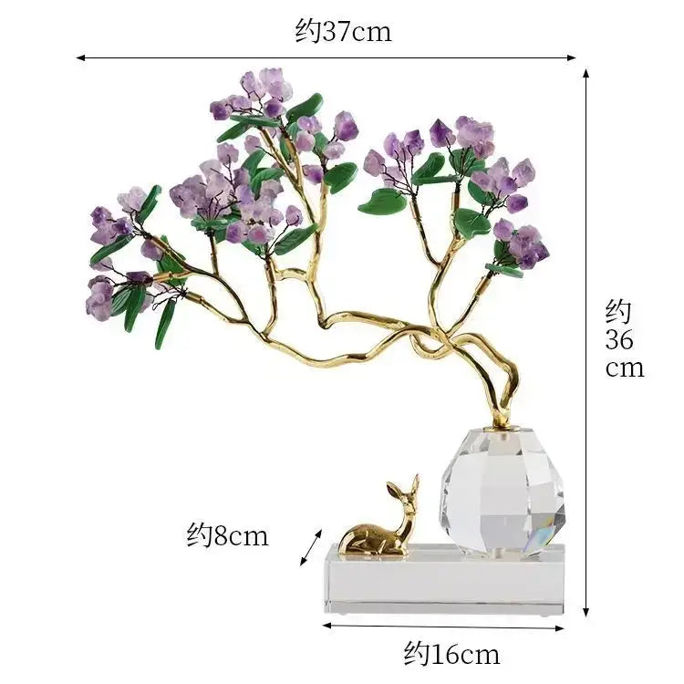 A delicate purple crystal flower tree with gold branches and green leaves on a clear base from decorbites chinese style crystal ornaments next to a small golden deer figurine