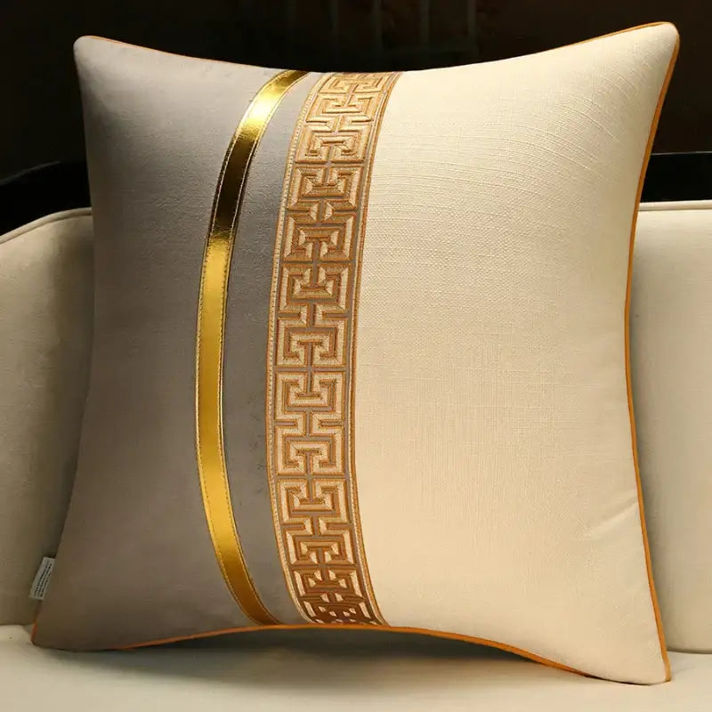 Cream-colored decorbites™ decorative pillow cover with gold metallic stripe and ornate geometric embroidery for sofa or bed