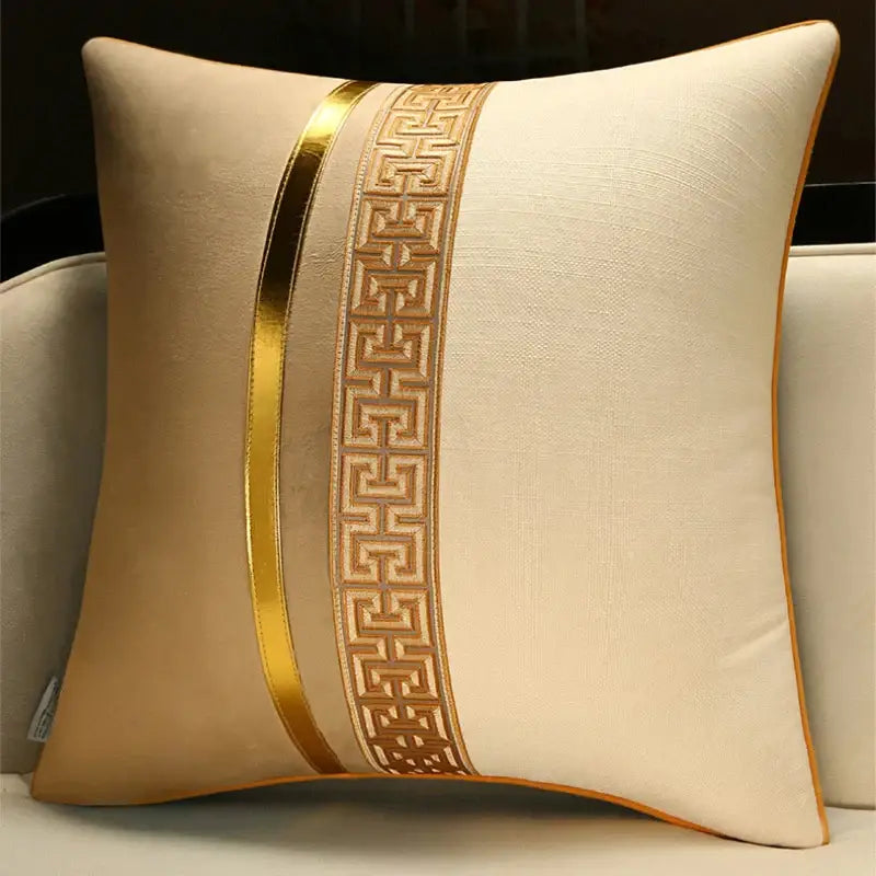 Cream-colored decorative pillow cover with vertical gold metallic stripe and embroidered greek key pattern for home use