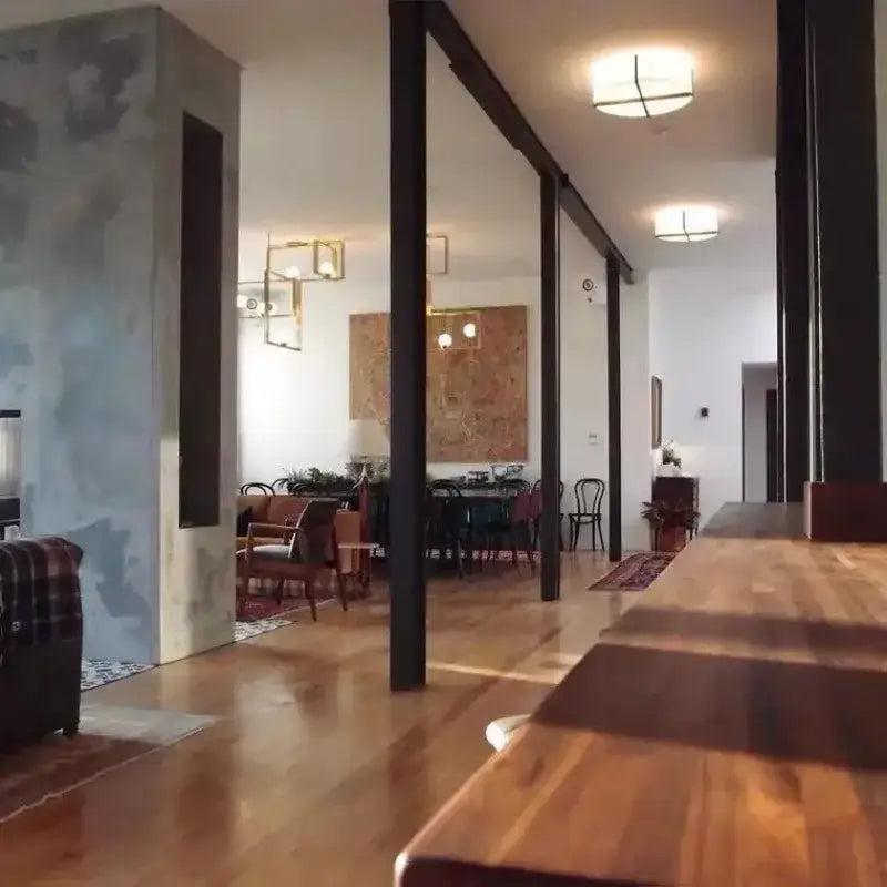 Long wooden dining table with polished surface and visible grain patterns paired with decorbites chinese style fabric ceiling lamp