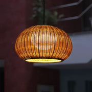 Warm-toned woven bamboo pendant light with glowing amber interior for outdoor rattan weaving pendant decor