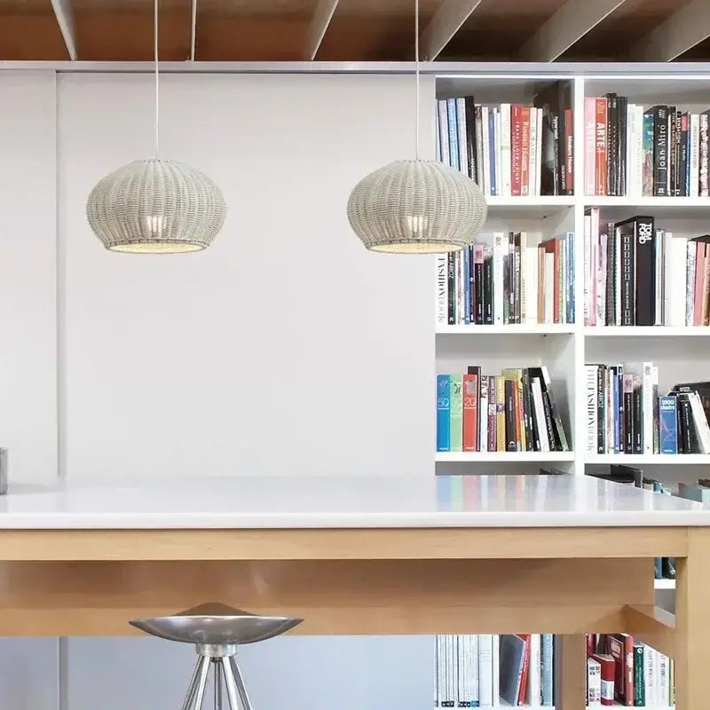 Two beige DecorBites™ Chinese style outdoor rattan weaving pendant lights hang above a white table