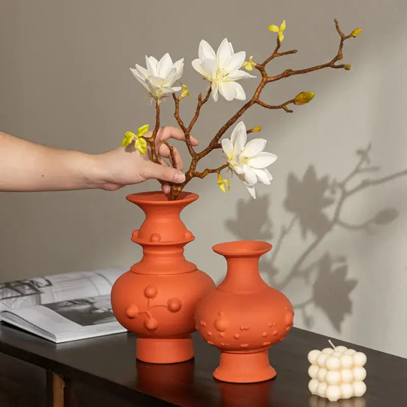 Handmade terracotta ceramic vase with textured rounded body and raised dots in retro ceramic style for home decor