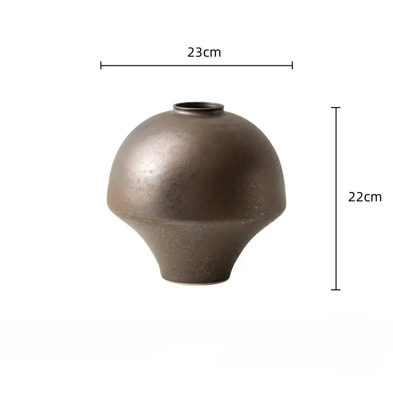 A matte bronze-colored handmade retro porcelain vase with a rounded body and flared base for home decoration