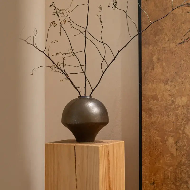Dark matte-finished ceramic retro porcelain vase with rounded body and tapered base for artistic home decoration