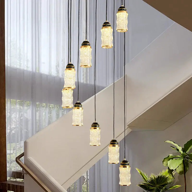Decorbites™ spiral staircase chandelier features elegant crystal-encrusted pendant lights with gold-toned caps for villa use