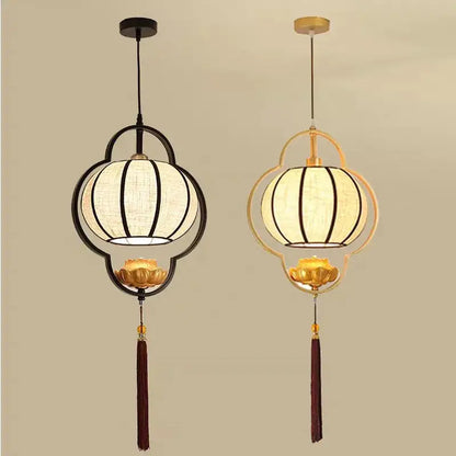 Two elegant decorbites™ teahouse lantern chandeliers with black and gold metal frames, white fabric shades, lotus bases, and tassels