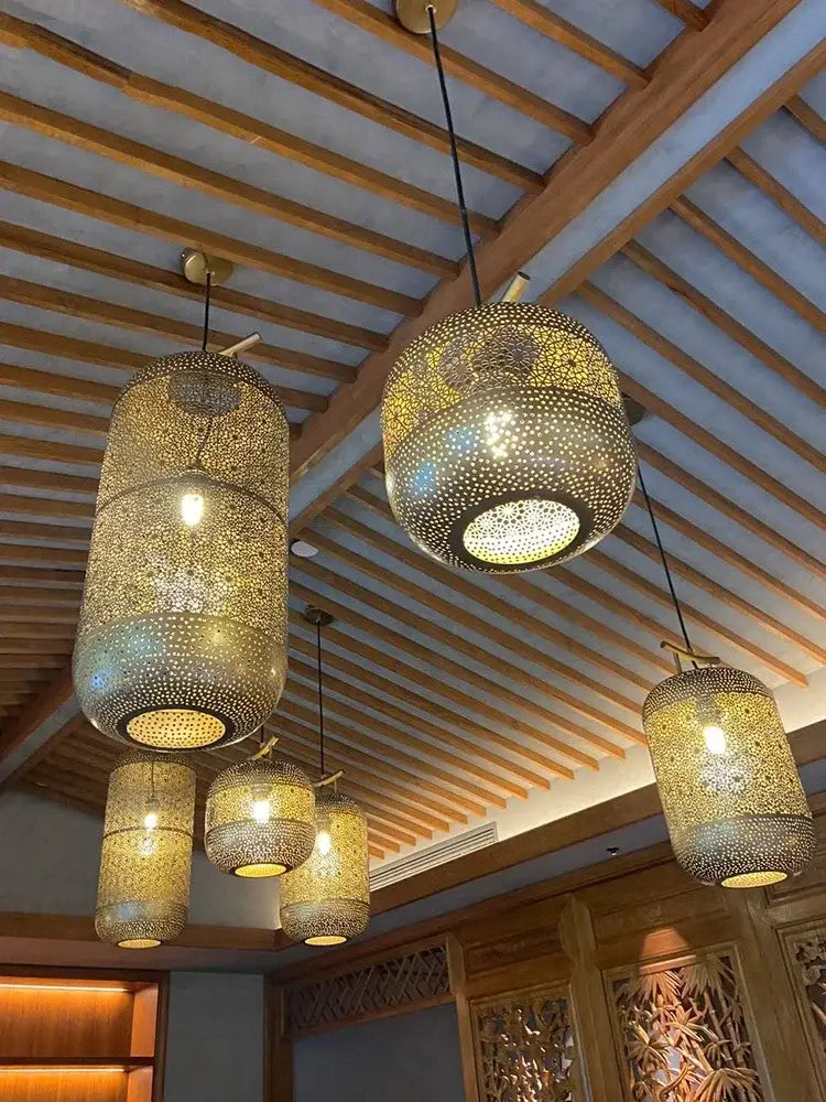 Gold-toned intricately perforated zen art birdcage pendant light with geometric pattern and small feet for restaurant use