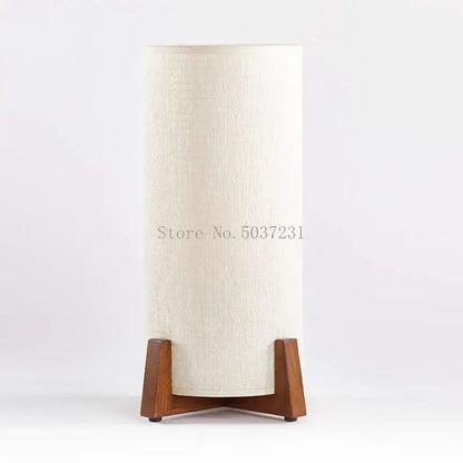 Cream-colored cylindrical lampshade with textured fabric on minimalist zen wooden floor lamp for living room or bedroom