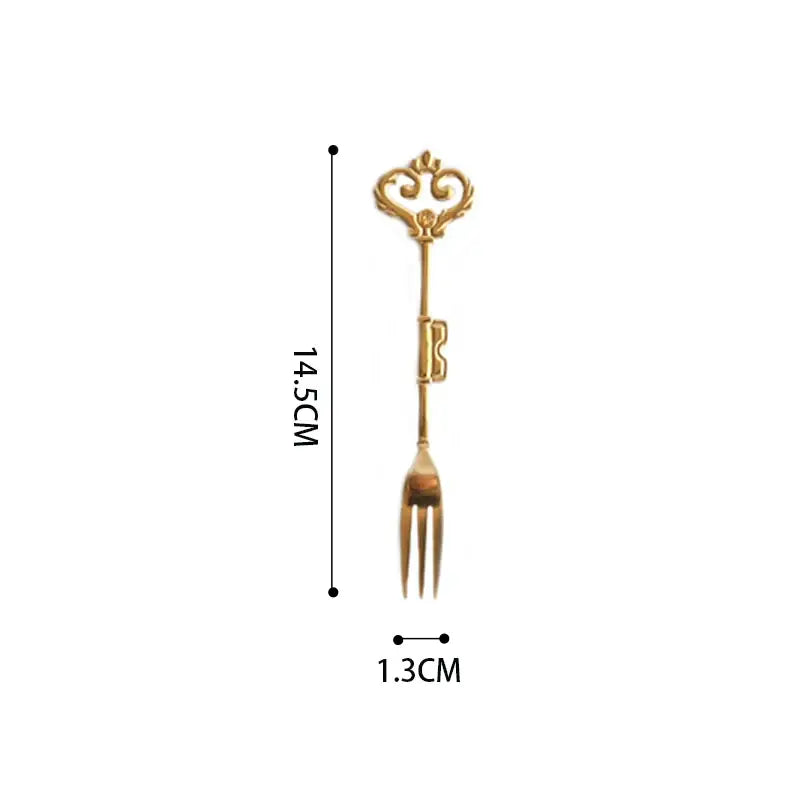 Gold-colored key-shaped dessert fork with ornate handle and three tines for decorbites chinoiserie floral birds dinner use