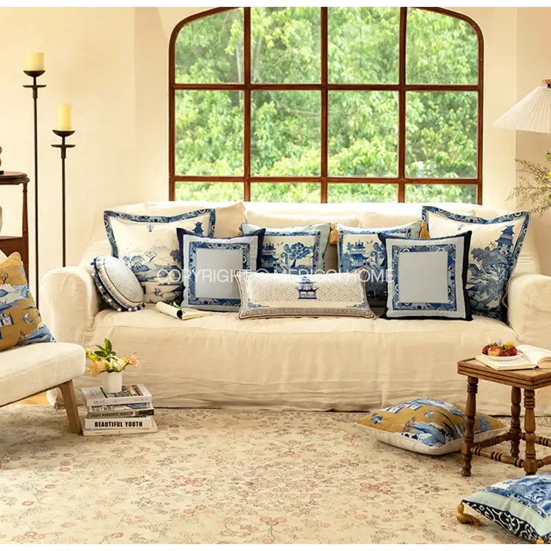 Cream-colored sofa with DecorBites™ chintz blue cobalt circular throw pillow covers featuring tassels and traditional designs
