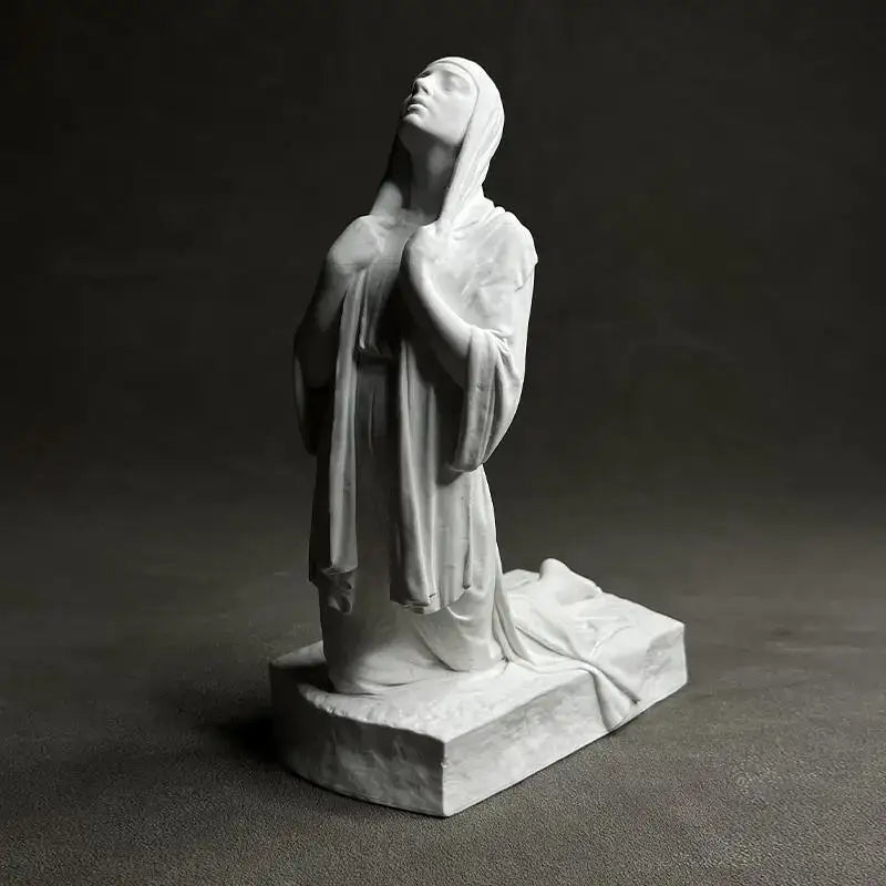 White marble Christian pray sculpture of a praying woman in flowing robes on a rectangular base by DecorBites™