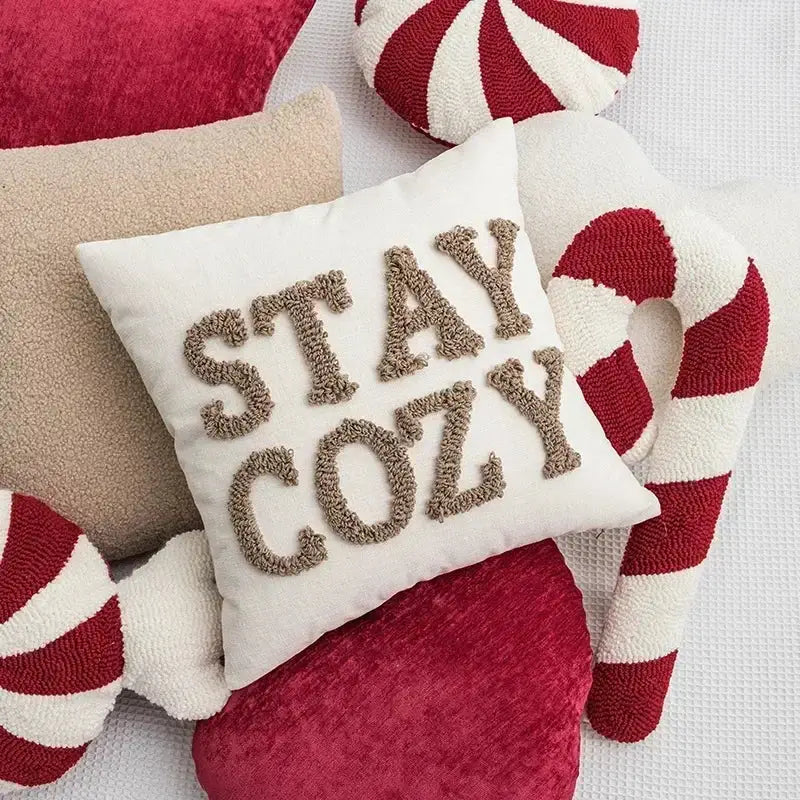 White square pillow with stay cozy embroidered in brown yarn from decorbites christmas candy cushions collection