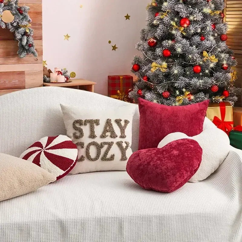 White textured couch with decorbites christmas candy cushions featuring a red velvet heart and peppermint-striped pillow