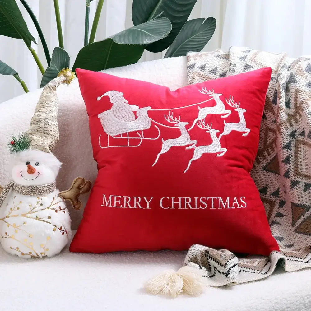Red velvet pillow cover with white embroidered santa in sleigh and merry christmas text from decorbites christmas cartoon set
