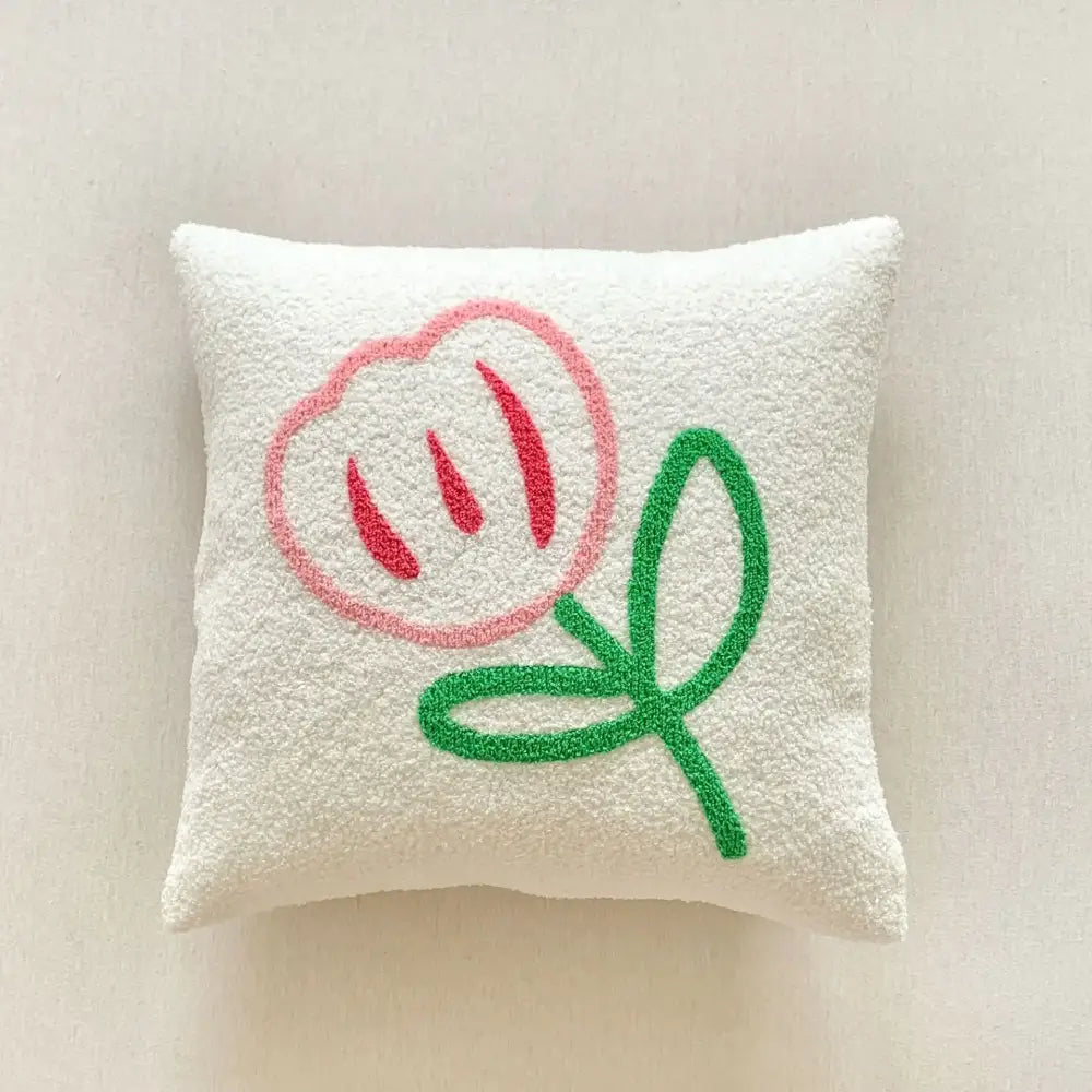 A soft white textured embroidered pillow from the decorbites christmas cartoon set featuring a pink flower design