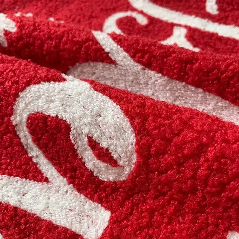 Red plush towel with white embroidered script design complementing decorbites christmas cartoon pillow covers for festive decor