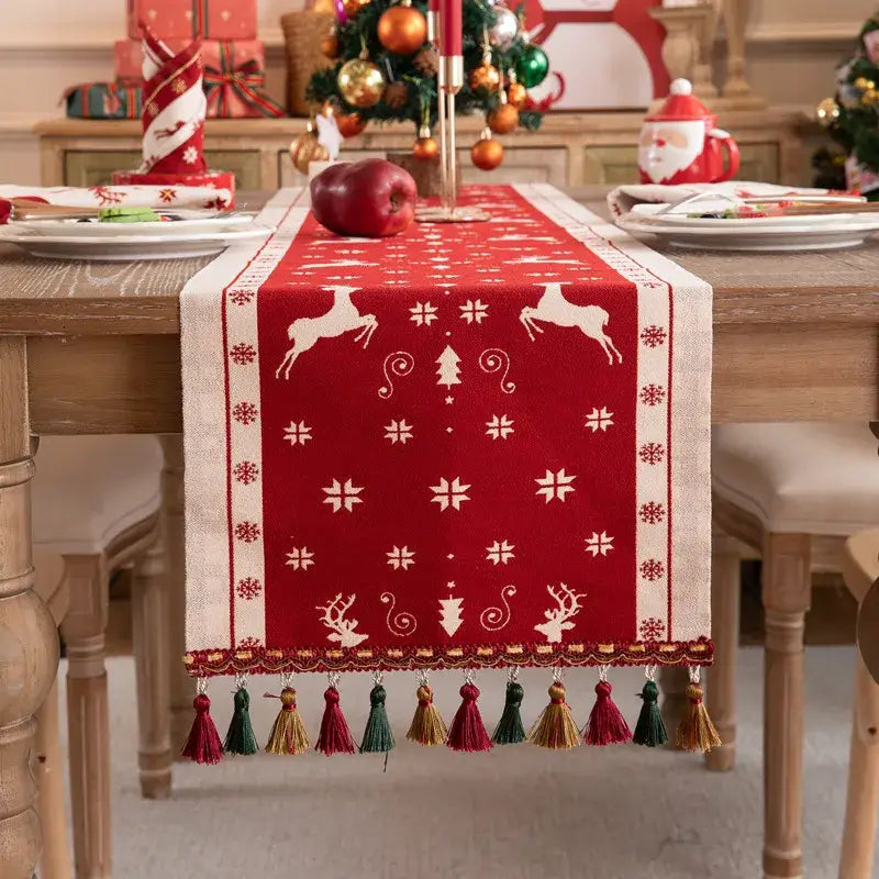DecorBites™ christmas table runner in red and cream with embroidered tassel featuring reindeer and snowflakes for dining room decor