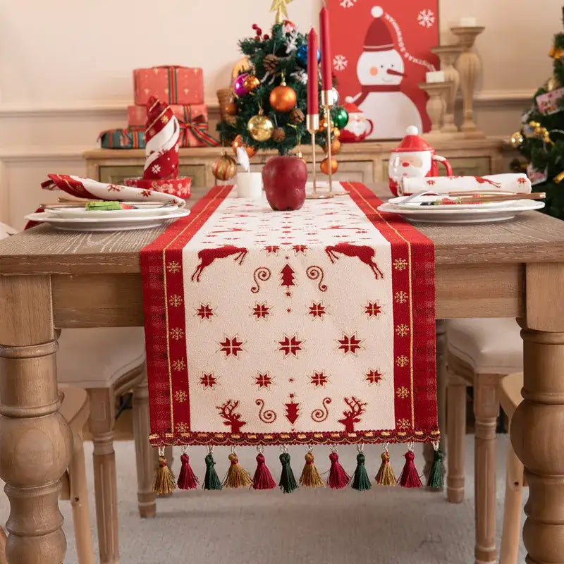 DecorBites™ christmas table runner in red and cream with embroidered reindeer snowflakes trees and colorful tassel fringe for dining room