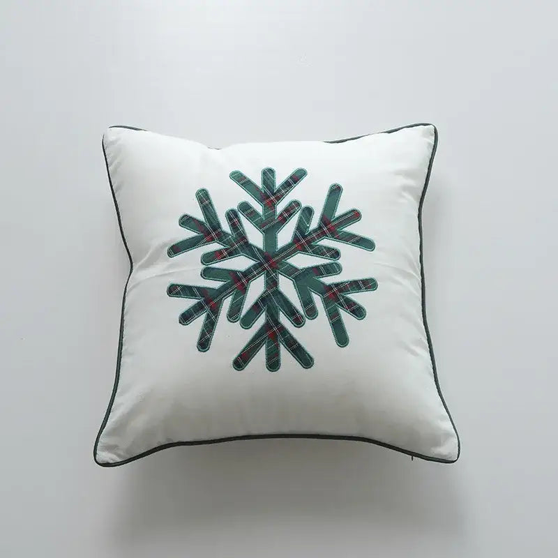 White square pillow cover with a central snowflake design in dark green and red plaid and black piping by decorbites christmas cartoon