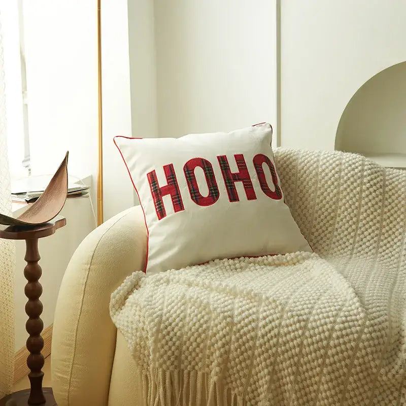 White cushion pillow cover with red ho ho lettering in plaid pattern and red stitched border decorbites christmas cartoon