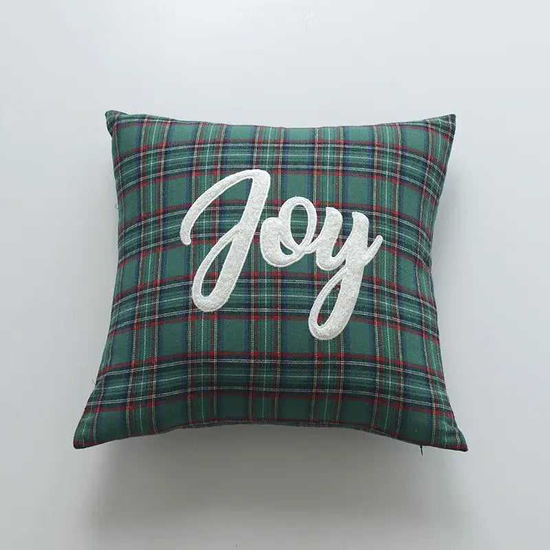 Green plaid pillow cover with white embroidered joy lettering from decorbites christmas cartoon festive collection